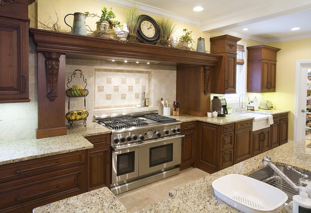 This is an example of a country kitchen in Chicago with an undermount sink, raised-panel cabinets, dark wood cabinets, beige splashback and stainless steel appliances.