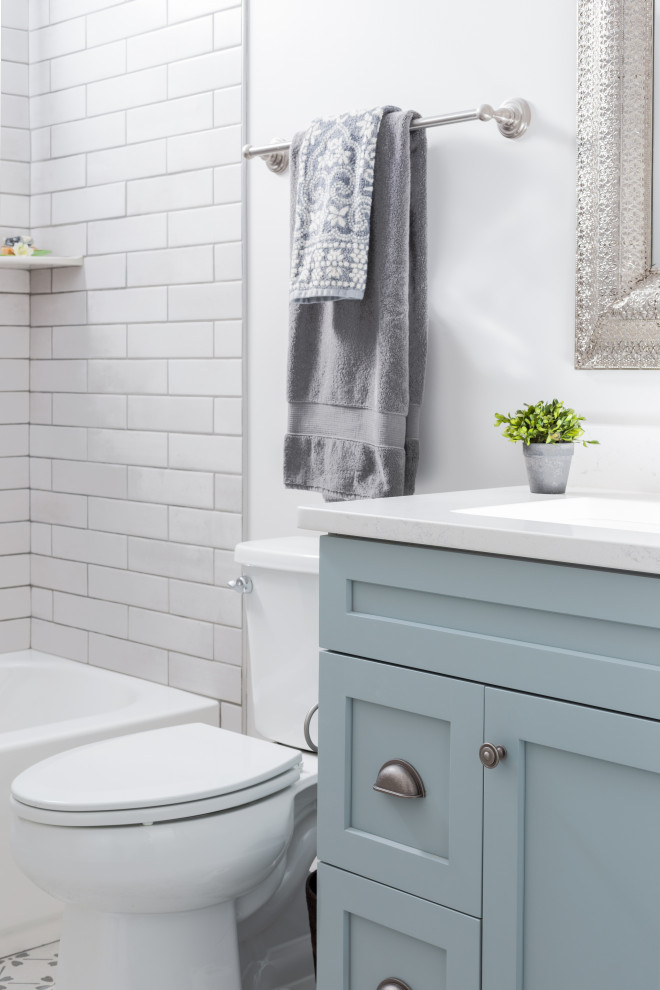 Example of a transitional white tile porcelain tile and single-sink freestanding bathtub design with shaker cabinets, blue cabinets, white walls, an undermount sink, quartz countertops, white countertops and a freestanding vanity