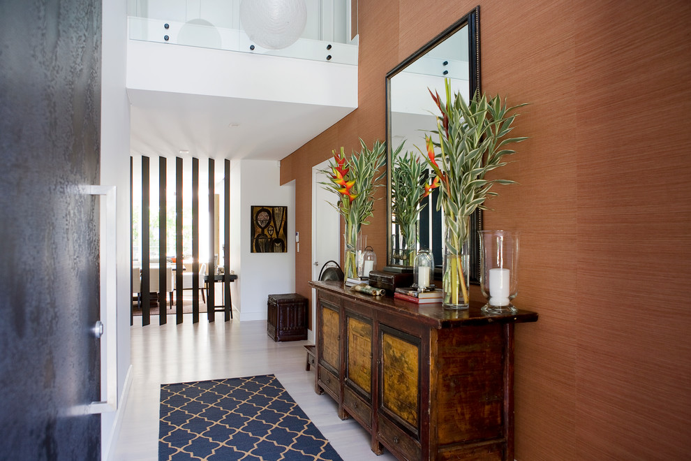 Photo of a contemporary entry hall in Sydney with orange walls, light hardwood floors and white floor.