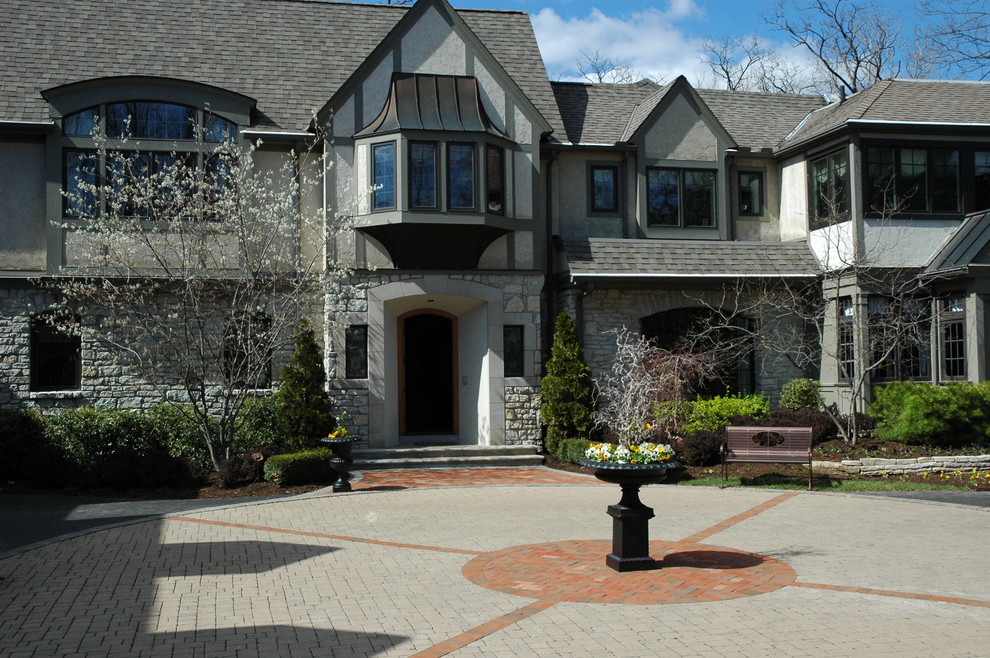 Design ideas for a traditional courtyard driveway in Columbus with brick pavers.
