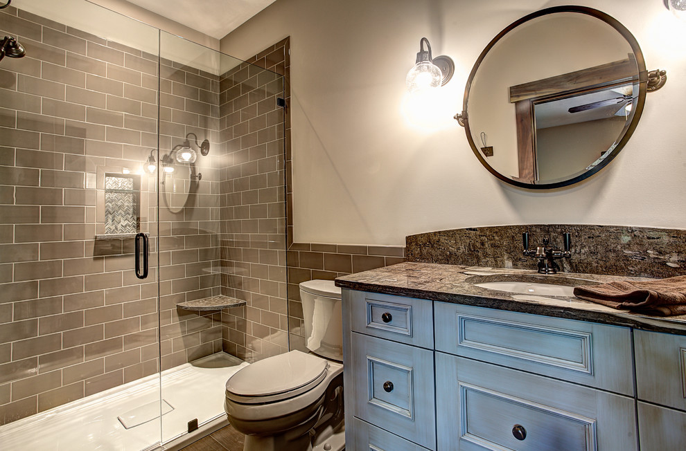 Inspiration for a mid-sized arts and crafts master bathroom in Grand Rapids with an undermount sink, shaker cabinets, blue cabinets, granite benchtops, an open shower, a two-piece toilet, gray tile, subway tile, beige walls and ceramic floors.