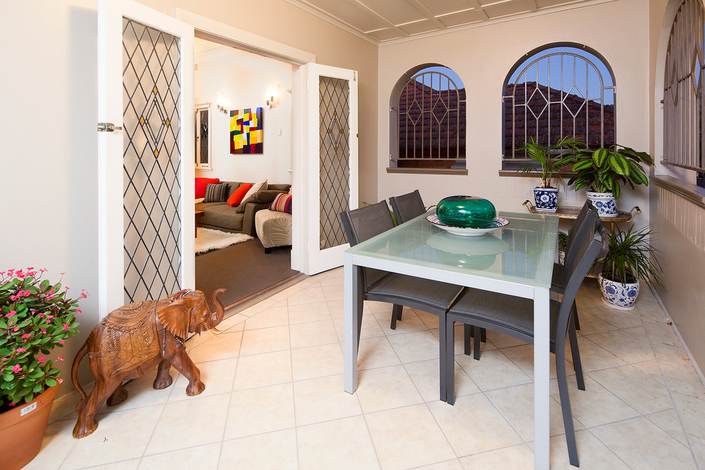 Mid-sized eclectic front yard screened-in verandah in Brisbane with tile and a roof extension.