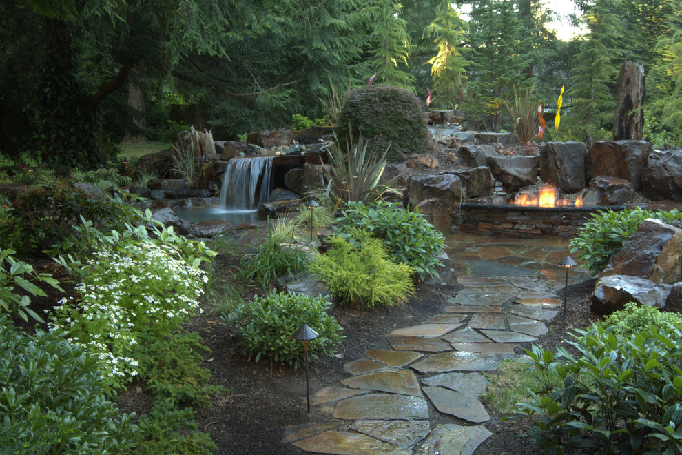 This is an example of a mid-sized contemporary backyard garden in Seattle with a fire feature and natural stone pavers.