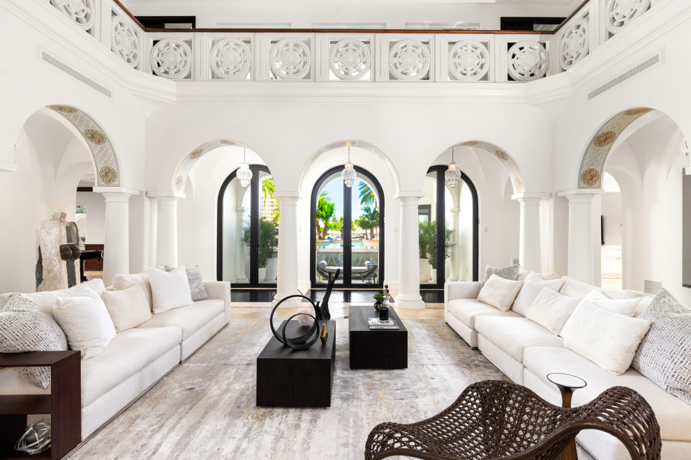 Inspiration for a mediterranean open plan living room in Miami with white walls and beige floors.