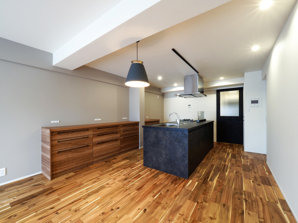 На фото: гостиная-столовая в стиле лофт с серыми стенами, паркетным полом среднего тона, коричневым полом, потолком с обоями и обоями на стенах с