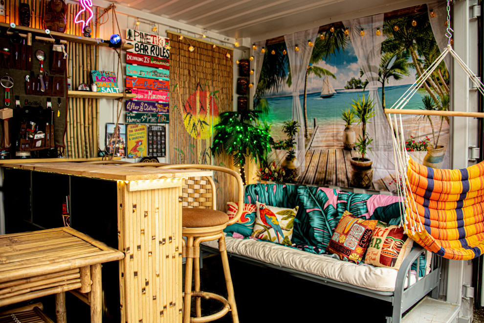 Esempio di un piccolo bancone bar tropicale con nessun'anta, ante in legno chiaro, top in legno, pavimento in legno verniciato e pavimento nero