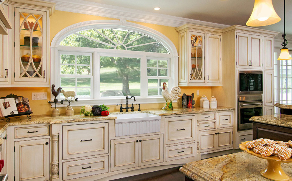 Large transitional l-shaped medium tone wood floor and brown floor open concept kitchen photo with a farmhouse sink, beaded inset cabinets, distressed cabinets, granite countertops, stainless steel appliances and an island