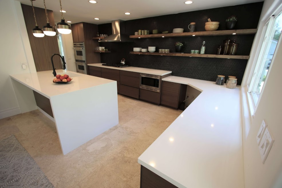 Foto på ett mellanstort funkis vit kök, med en enkel diskho, skåp i shakerstil, bruna skåp, laminatbänkskiva, svart stänkskydd, stänkskydd i keramik, rostfria vitvaror, klinkergolv i keramik, en köksö och flerfärgat golv