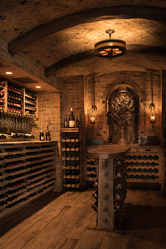 Mediterranean wine cellar in Orange County with dark hardwood floors and storage racks.