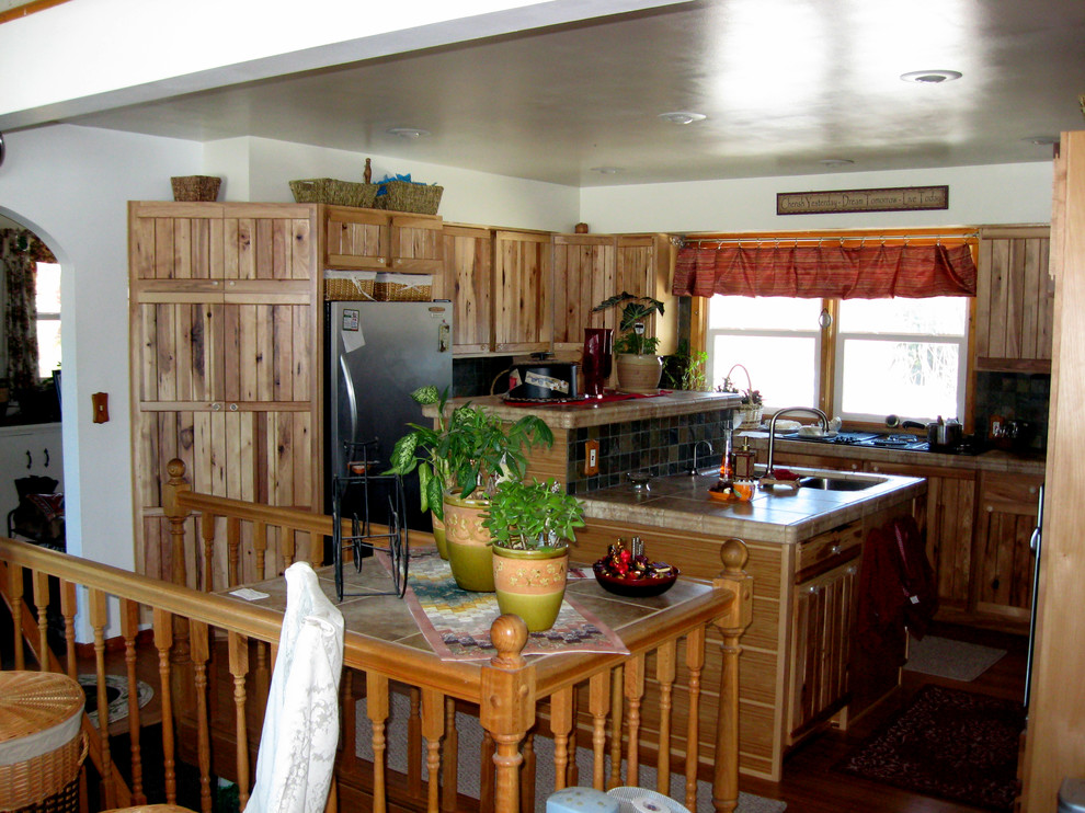 Mid-sized mountain style u-shaped bamboo floor eat-in kitchen photo in Seattle with an undermount sink, tile countertops, stone tile backsplash, stainless steel appliances and an island