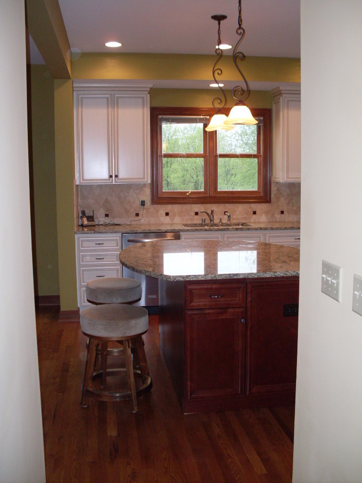 Mid-sized transitional u-shaped dark wood floor open concept kitchen photo in Cincinnati with an undermount sink, recessed-panel cabinets, white cabinets, granite countertops, beige backsplash, ceramic backsplash, stainless steel appliances and an island