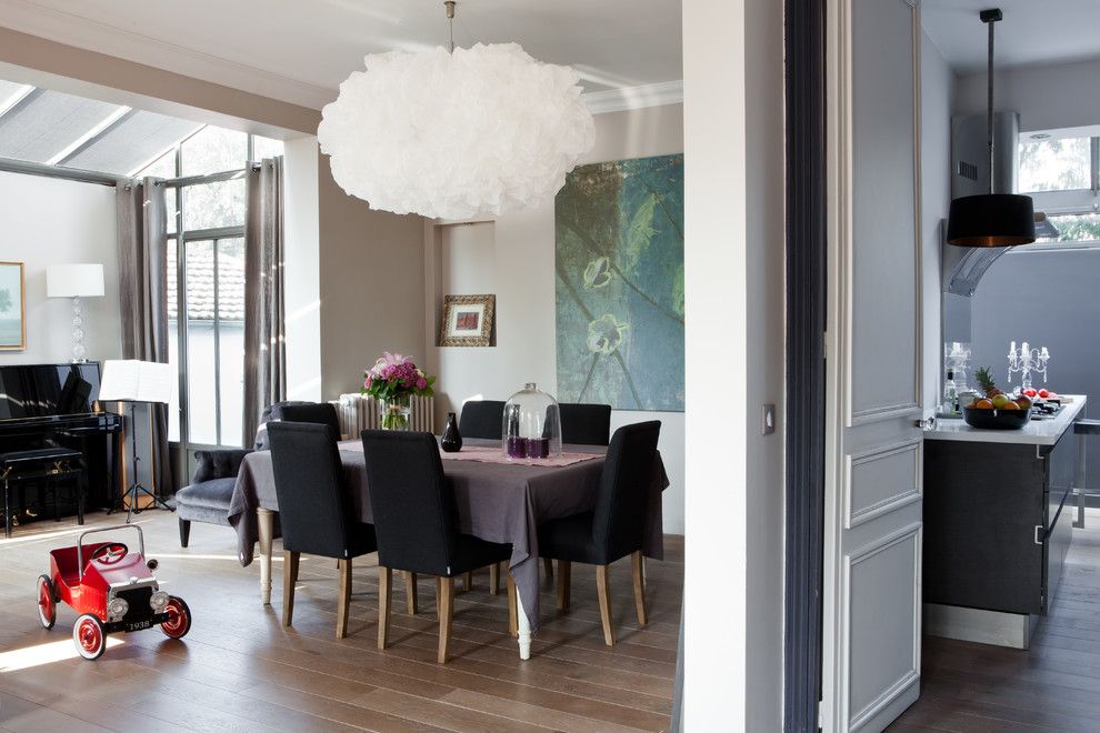 Photo of a mid-sized contemporary open plan dining in Paris with beige walls, light hardwood floors and no fireplace.