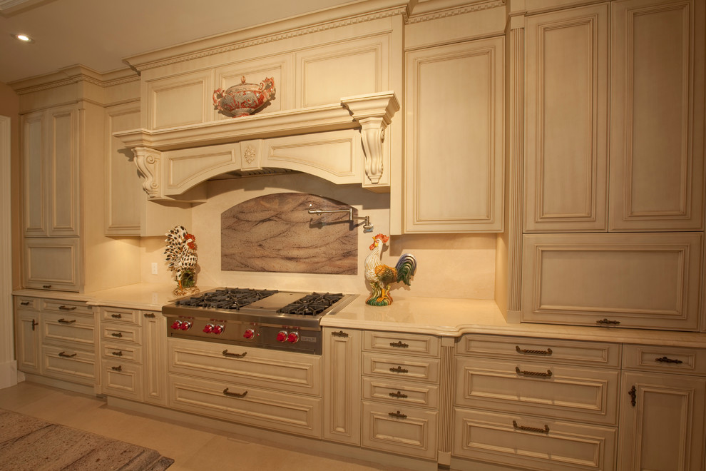 Photo of a large traditional l-shaped separate kitchen in Dallas with an undermount sink, raised-panel cabinets, distressed cabinets, marble benchtops, beige splashback, stone tile splashback, panelled appliances, travertine floors and with island.