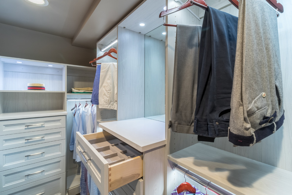 This is an example of a mid-sized contemporary men's walk-in wardrobe in Minneapolis with shaker cabinets, light wood cabinets and carpet.