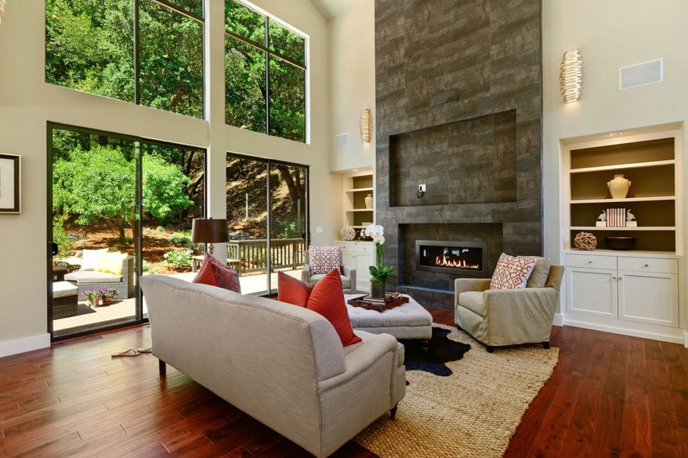 Mid-sized transitional formal enclosed living room in San Francisco with white walls, medium hardwood floors, a standard fireplace, a stone fireplace surround, no tv and brown floor.