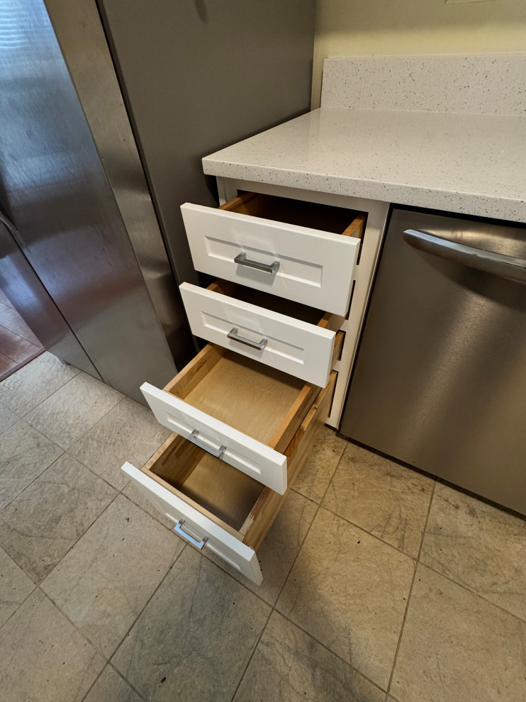 Mid-sized transitional l-shaped enclosed kitchen photo in Chicago with shaker cabinets, white cabinets, quartz countertops and white countertops