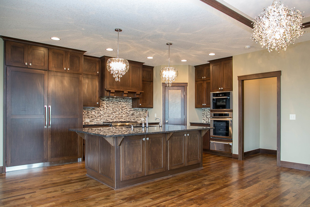 Open concept kitchen - transitional l-shaped dark wood floor open concept kitchen idea in Minneapolis with a drop-in sink, shaker cabinets, dark wood cabinets, granite countertops, multicolored backsplash, ceramic backsplash, stainless steel appliances and an island