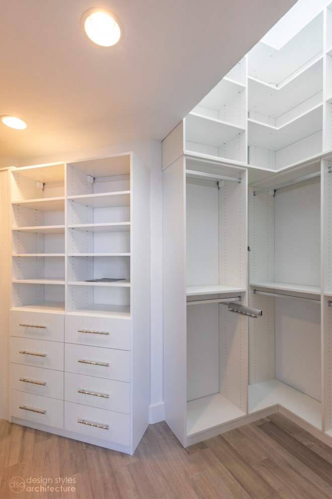 Photo of a modern gender-neutral dressing room with flat-panel cabinets, white cabinets and vinyl floors.