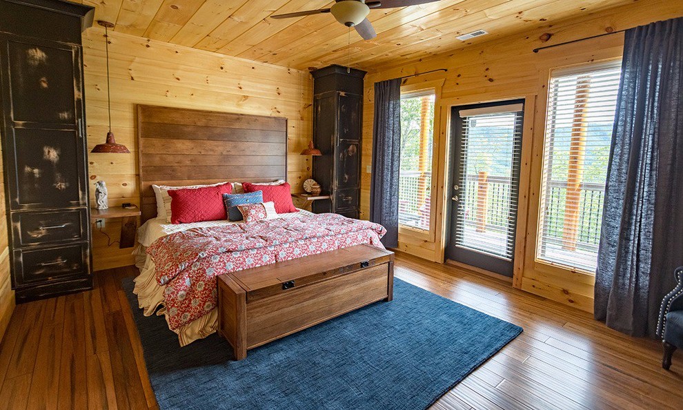 Mid-sized country guest bedroom in Other with yellow walls, bamboo floors, no fireplace and brown floor.