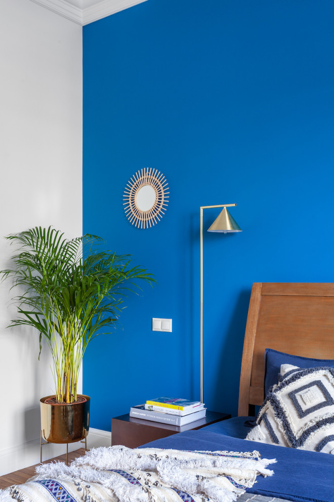 Foto di una camera matrimoniale eclettica di medie dimensioni con pareti blu e pavimento in legno massello medio