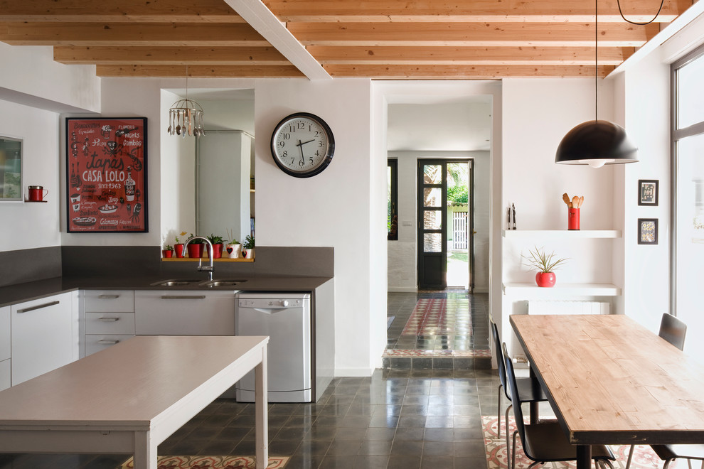 This is an example of a mid-sized contemporary u-shaped eat-in kitchen in Barcelona with an undermount sink, flat-panel cabinets, white cabinets, grey splashback, metal splashback, stainless steel appliances, ceramic floors and no island.