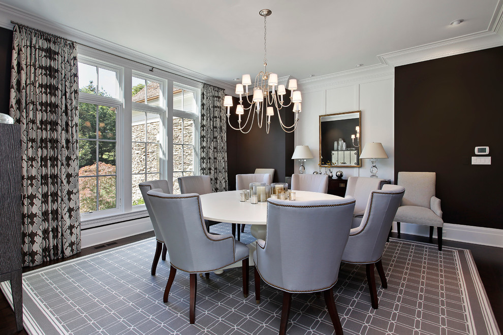 This is an example of a transitional dining room in Chicago with black walls.
