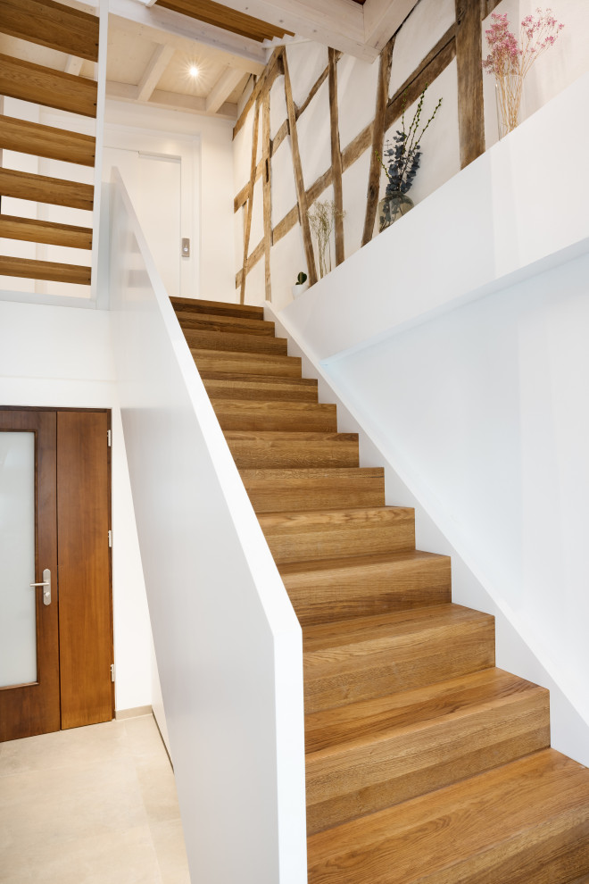 Contemporary wood staircase in Stuttgart with wood risers and wood railing.