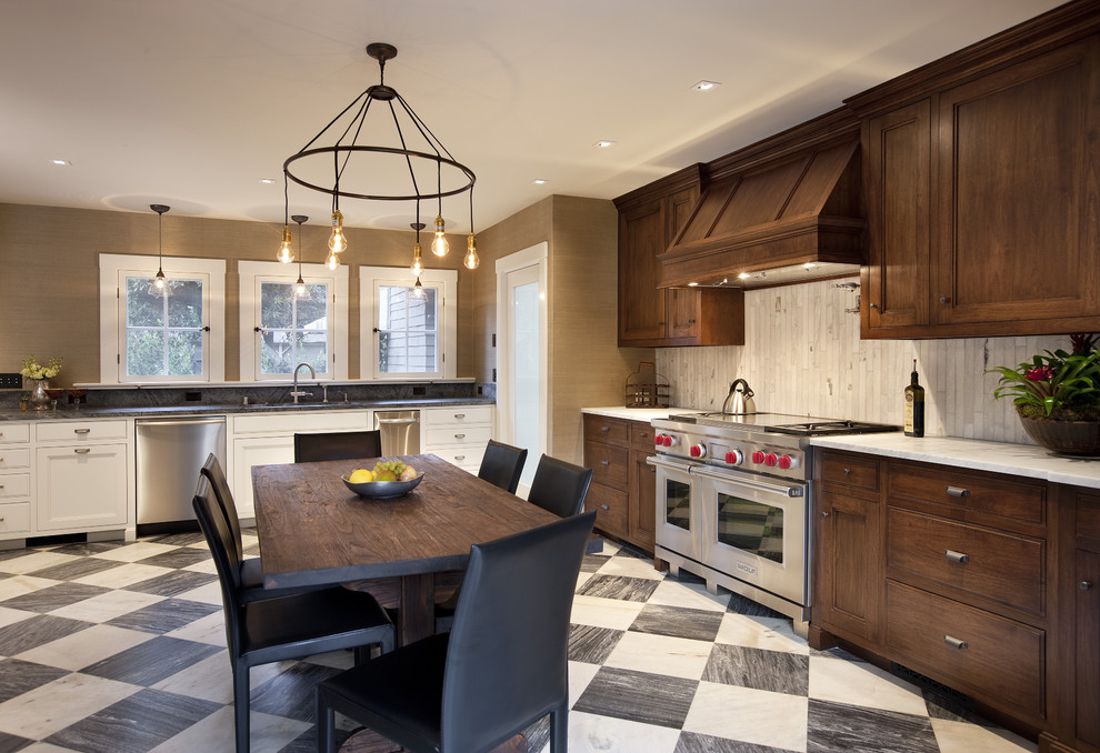 This is an example of a traditional l-shaped eat-in kitchen in Santa Barbara with shaker cabinets, dark wood cabinets, white splashback, stainless steel appliances and no island.