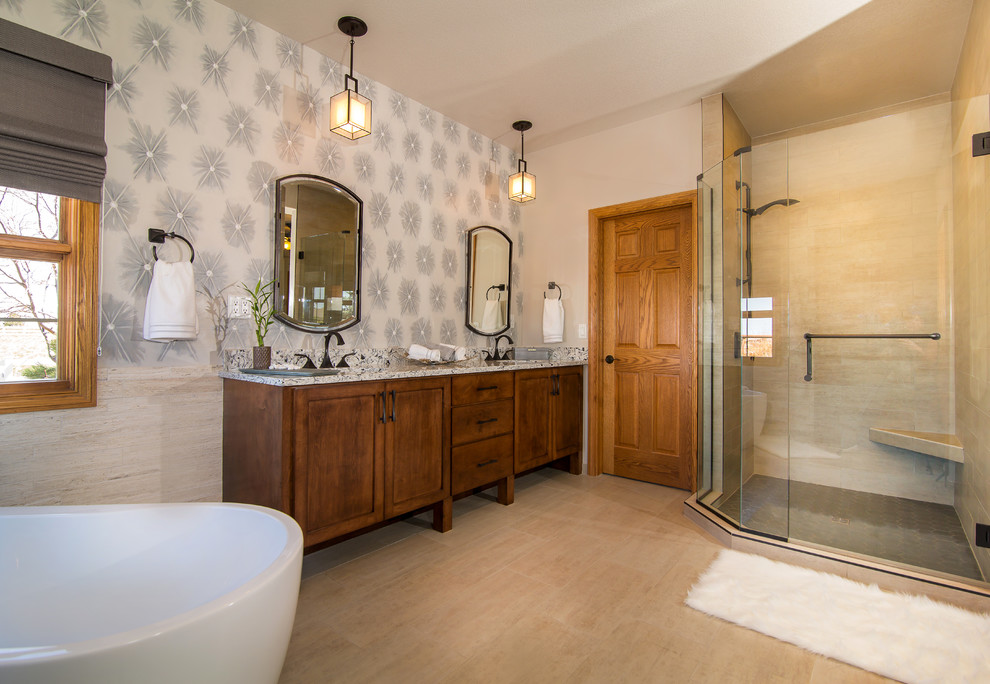 Mid-sized transitional master beige tile and porcelain tile porcelain tile and beige floor freestanding bathtub photo in Denver with raised-panel cabinets, medium tone wood cabinets, multicolored walls, an undermount sink, granite countertops and a hinged shower door