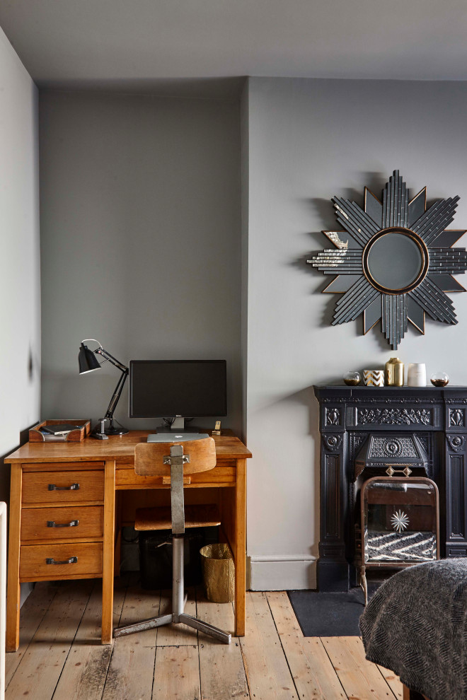 Cette photo montre un petit bureau éclectique avec un mur gris, parquet clair, une cheminée standard, un manteau de cheminée en métal, un bureau indépendant et un sol beige.