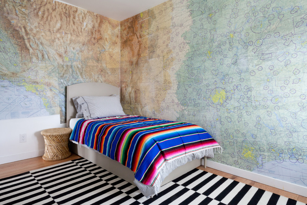Photo of an eclectic gender-neutral kids' bedroom in Los Angeles with multi-coloured walls and medium hardwood floors.