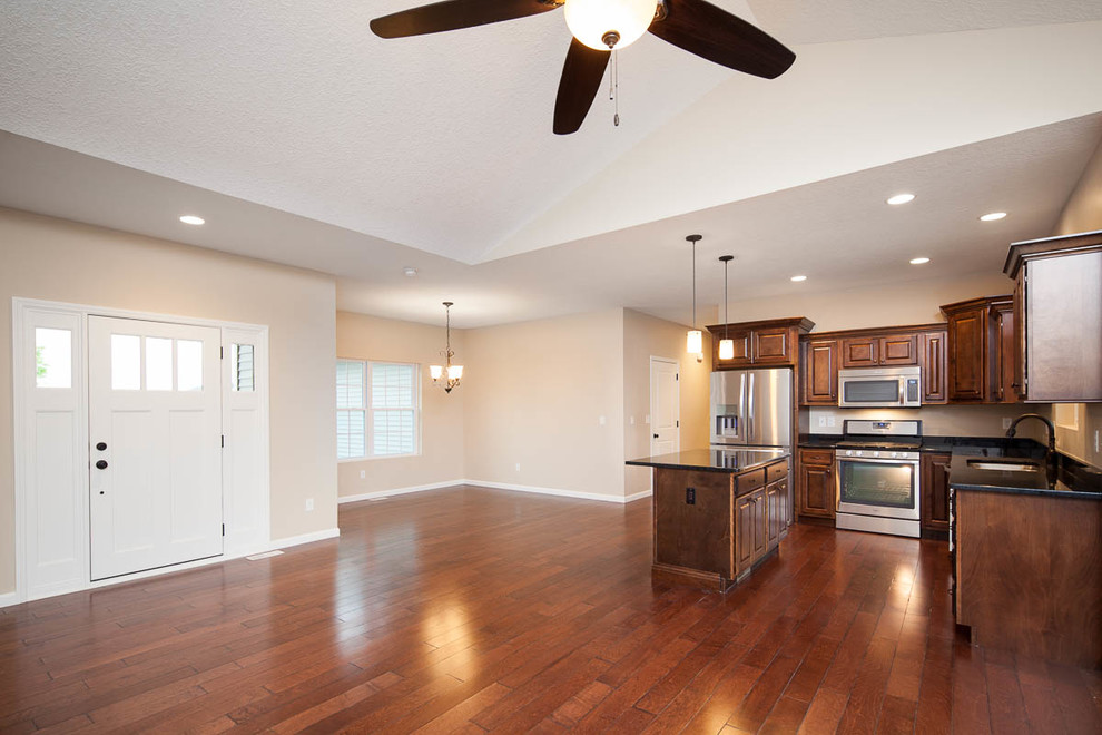 Eat-in kitchen - transitional dark wood floor eat-in kitchen idea in Chicago with a double-bowl sink, dark wood cabinets, granite countertops, stainless steel appliances and an island