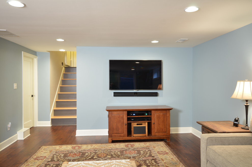 Design ideas for a mid-sized traditional look-out basement in Portland with blue walls and dark hardwood floors.