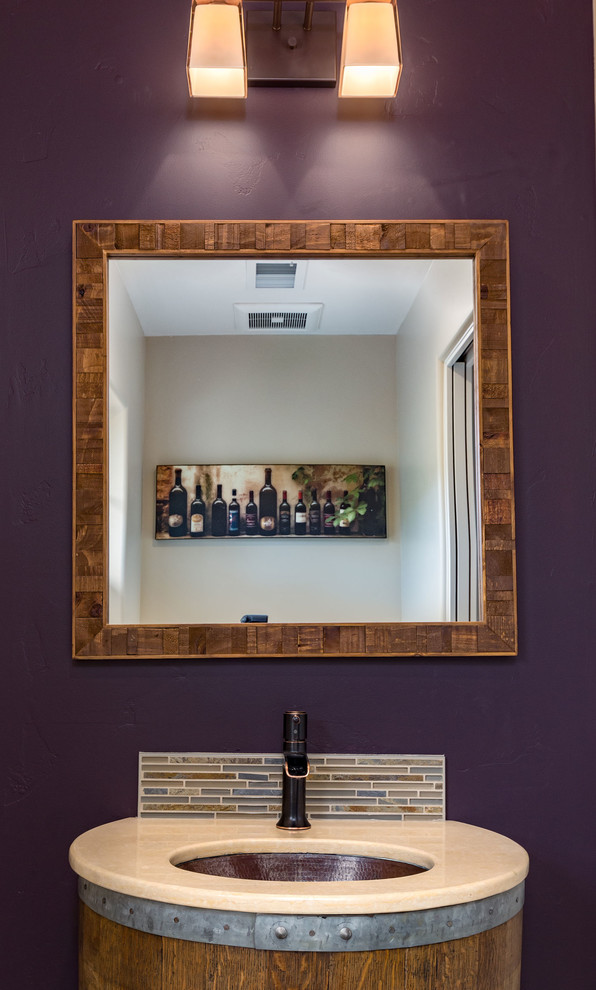 Example of a small country bathroom design with medium tone wood cabinets, purple walls, a wall-mount sink and solid surface countertops