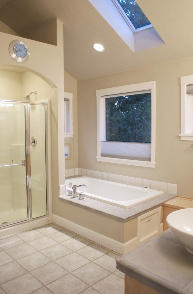 This is an example of a mid-sized modern master bathroom in Portland with a vessel sink, light wood cabinets, tile benchtops, a drop-in tub, an alcove shower, a two-piece toilet, gray tile, porcelain tile, beige walls and linoleum floors.