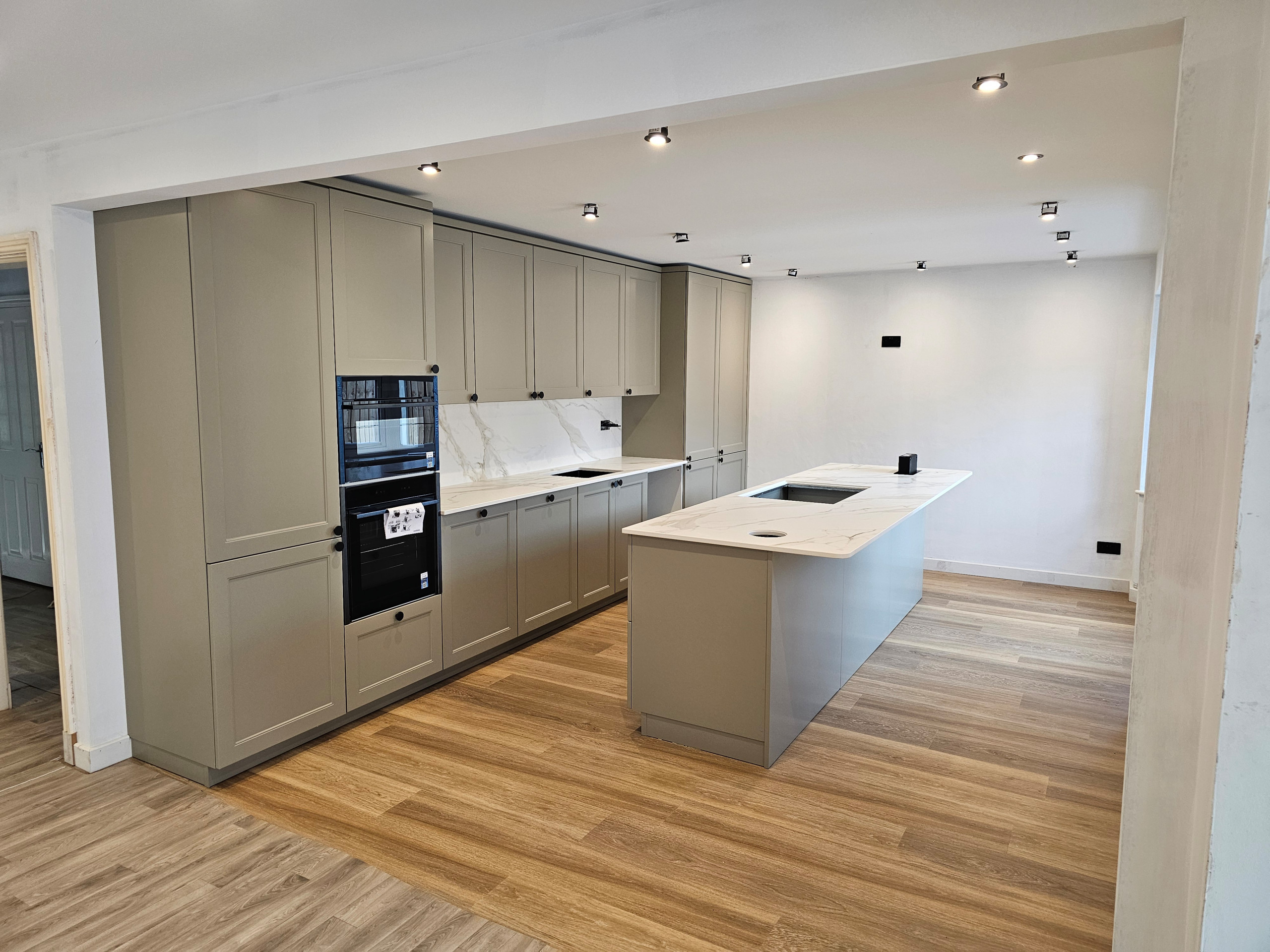 Neolith Calacatta Roma Silk worktops compliment the cabinets beautifully - the foreground woodgrain is just to protect the flooring underneath, it will be the same throughout once the work is complete