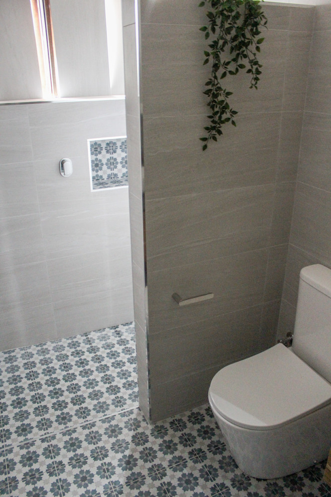 Small modern 3/4 bathroom in Perth with flat-panel cabinets, dark wood cabinets, an open shower, a one-piece toilet, gray tile, porcelain tile, grey walls, ceramic floors, a vessel sink, engineered quartz benchtops, multi-coloured floor, an open shower and black benchtops.