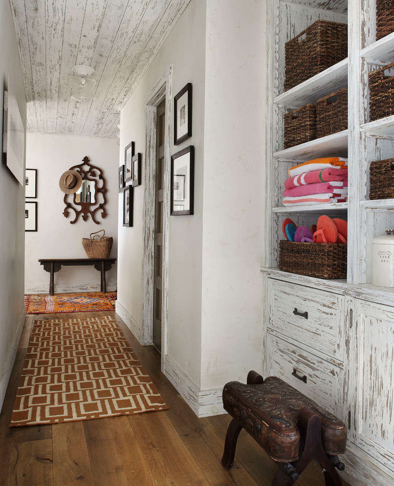 Inspiration for a country hallway in Milwaukee with white walls and dark hardwood floors.