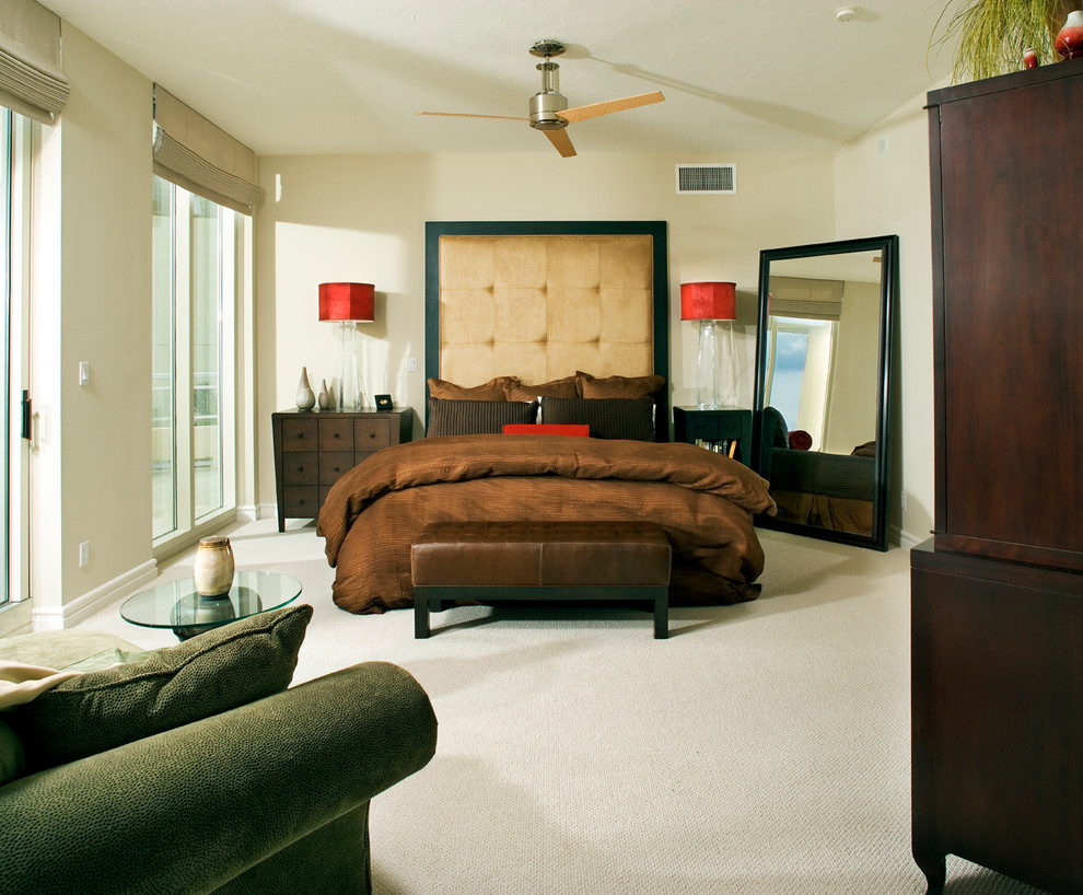 Contemporary bedroom in Miami with beige walls and carpet.