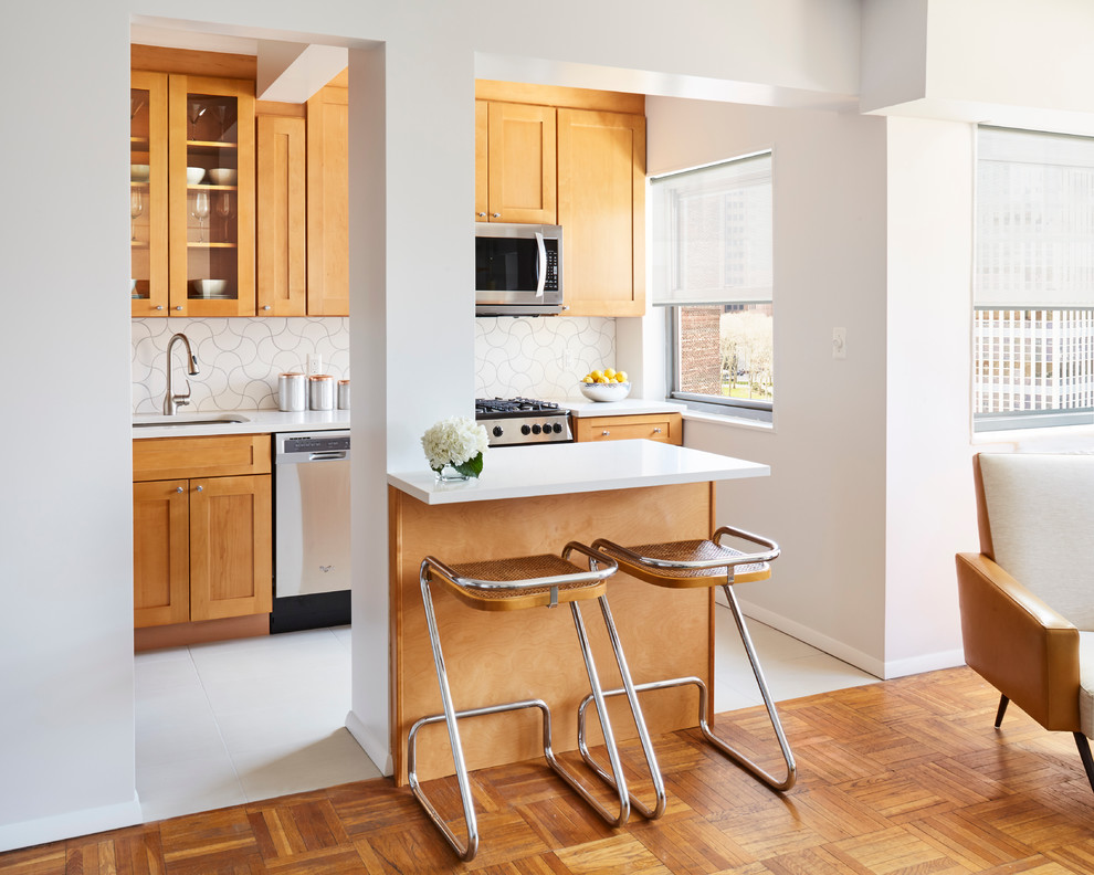 Design ideas for a small midcentury l-shaped eat-in kitchen in New York with an undermount sink, shaker cabinets, orange cabinets, quartzite benchtops, white splashback, ceramic splashback, stainless steel appliances, porcelain floors and with island.