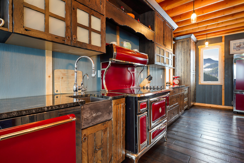 Inspiration for a large rustic galley eat-in kitchen remodel with a farmhouse sink, recessed-panel cabinets, brown cabinets, wood countertops, colored appliances and an island
