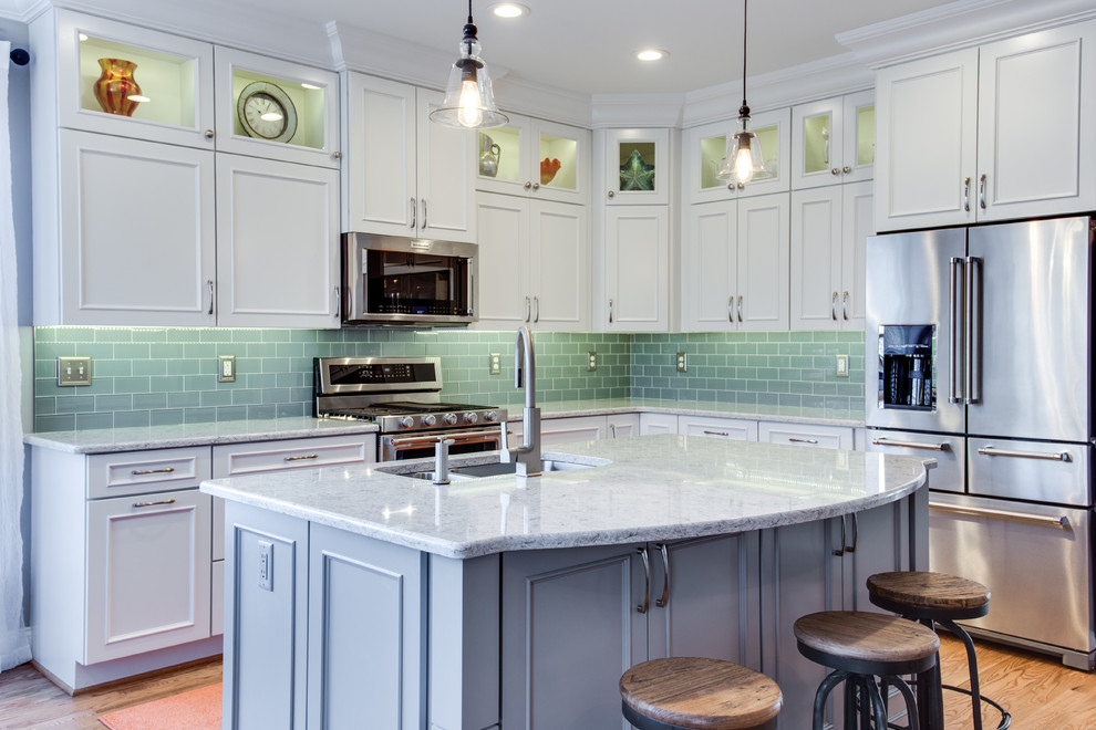 Example of a mid-sized transitional l-shaped medium tone wood floor kitchen design in Baltimore with an undermount sink, recessed-panel cabinets, white cabinets, quartz countertops, green backsplash, subway tile backsplash, stainless steel appliances and an island