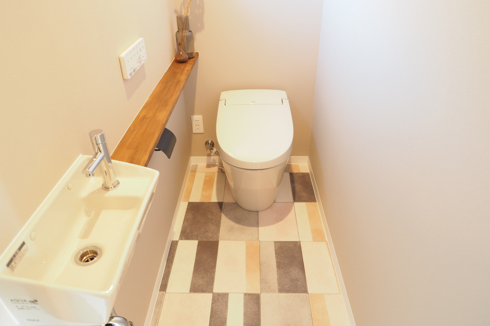 Design ideas for an urban cloakroom in Other with white cabinets, a one-piece toilet, beige tiles, beige walls, brown worktops, a built in vanity unit and wallpapered walls.