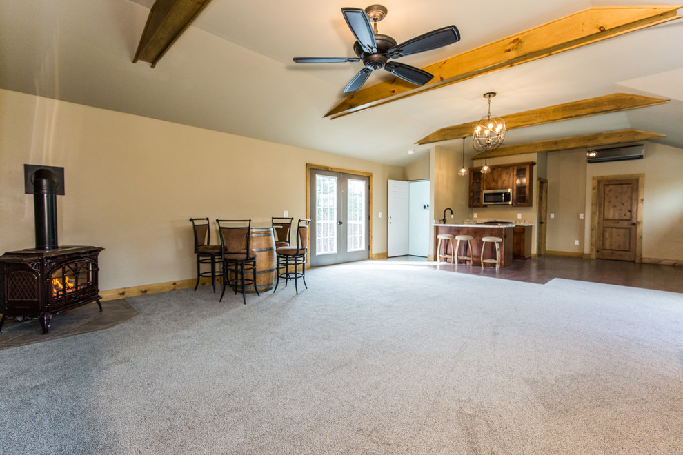 Photo of a large country open concept living room in Providence with a home bar, brown walls, carpet, a corner fireplace, a wall-mounted tv and grey floor.