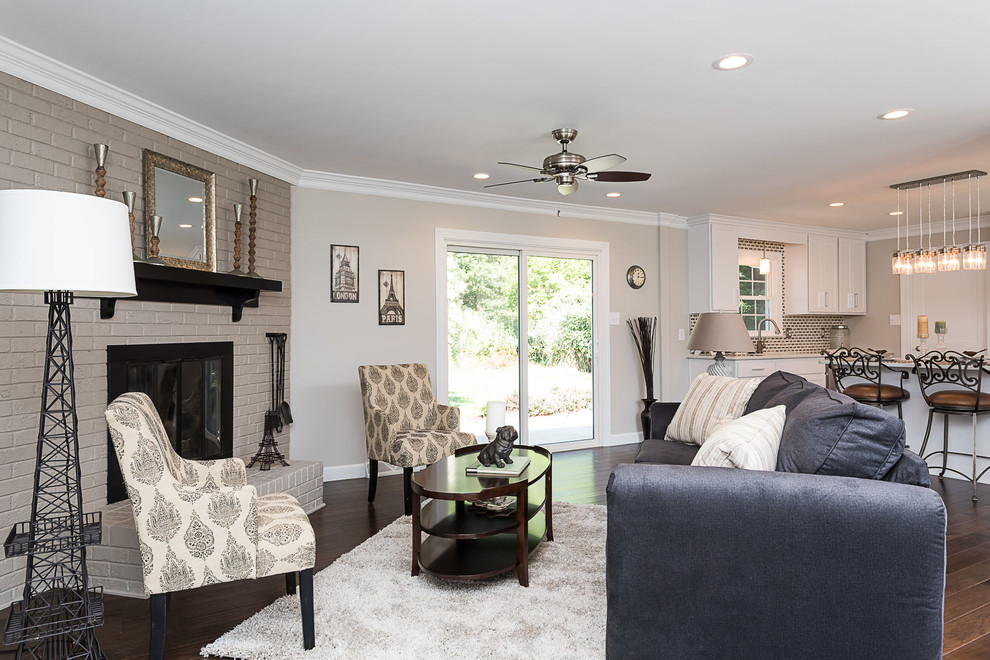 Inspiration for a mid-sized transitional formal open concept living room in Raleigh with black walls, dark hardwood floors, a standard fireplace, a brick fireplace surround, no tv and brown floor.