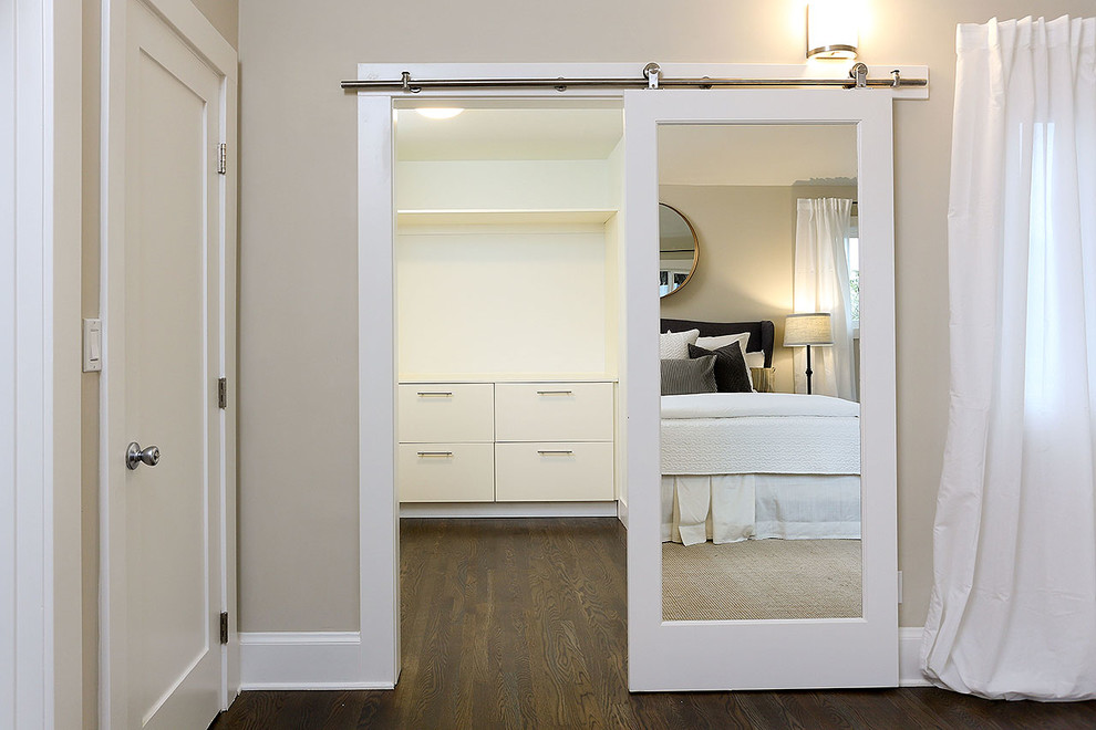 Inspiration for a mid-sized transitional gender-neutral walk-in wardrobe in San Francisco with flat-panel cabinets, white cabinets, dark hardwood floors and brown floor.