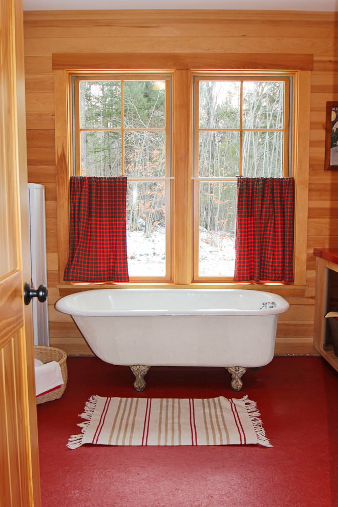 Photo of a mid-sized country master bathroom in Portland Maine with a claw-foot tub, open cabinets, light wood cabinets, terrazzo floors, a trough sink, solid surface benchtops and red floor.