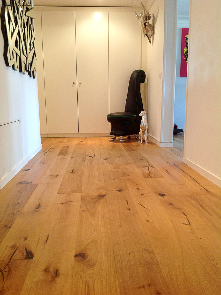 Large mountain style medium tone wood floor hallway photo with white walls