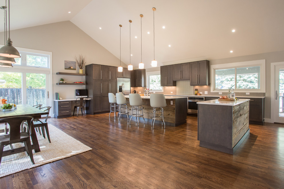Open concept kitchen - large transitional l-shaped dark wood floor open concept kitchen idea in Denver with stainless steel appliances, shaker cabinets, dark wood cabinets and two islands