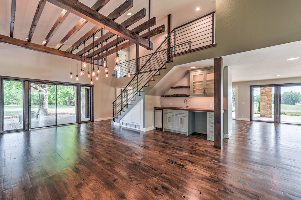 Large cottage dark wood floor and brown floor great room photo in Oklahoma City with gray walls and no fireplace